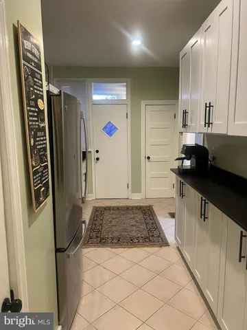 a kitchen with granite countertop a refrigerator and a sink