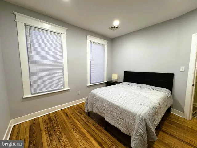 a bedroom with a bed and wooden floor