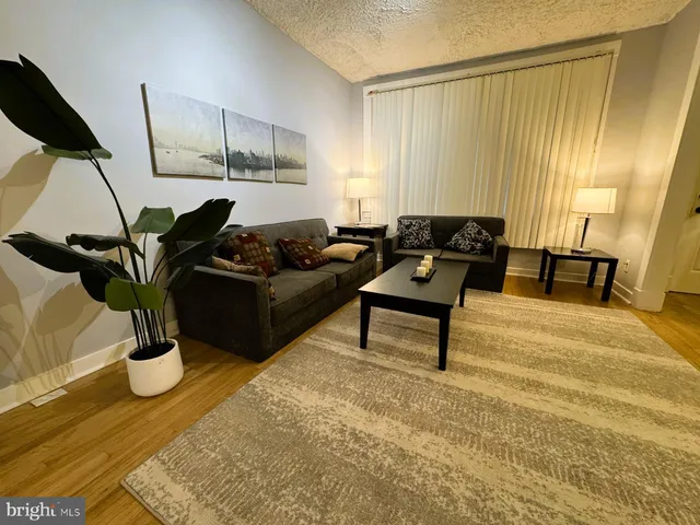 a living room with a rug table and a window