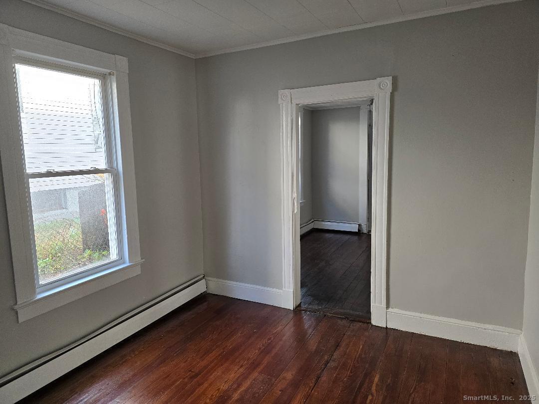 133 South Street, Unit 1 Waterbury, CT 06706 - Photo 5 of 6 an empty room with wooden floor and a window