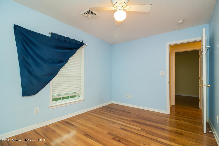 1320 Squirrel Road Wall, NJ 07719 - Photo 20 of 24 a view of empty room with wooden floor and fan