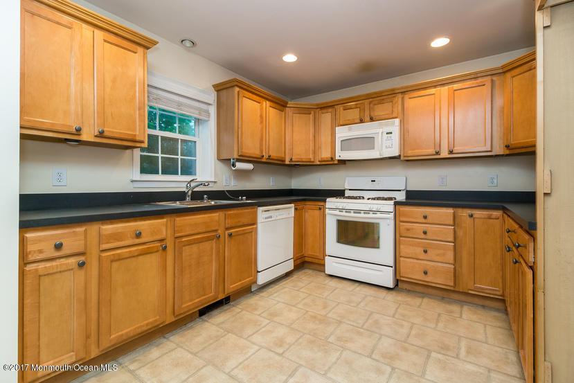 1320 Squirrel Road Wall, NJ 07719 - Photo 4 of 24 a kitchen with stainless steel appliances granite countertop a stove a sink and a microwave