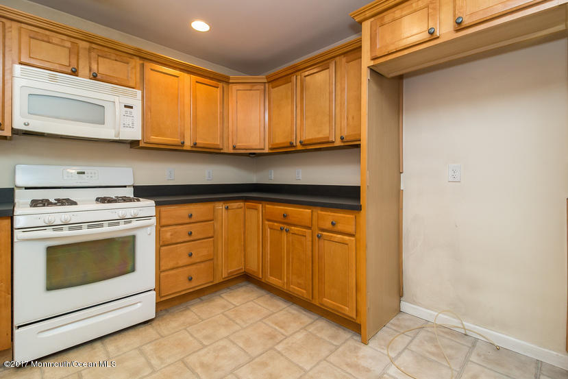 1320 Squirrel Road Wall, NJ 07719 - Photo 5 of 24 a kitchen with stainless steel appliances granite countertop a stove a sink and a microwave