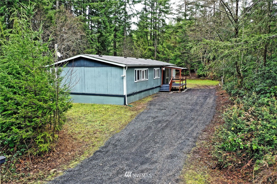 111 East Sleaford Road Shelton, WA 98584 - Photo 1 of 32 a backyard of a house with wooden fence and large trees