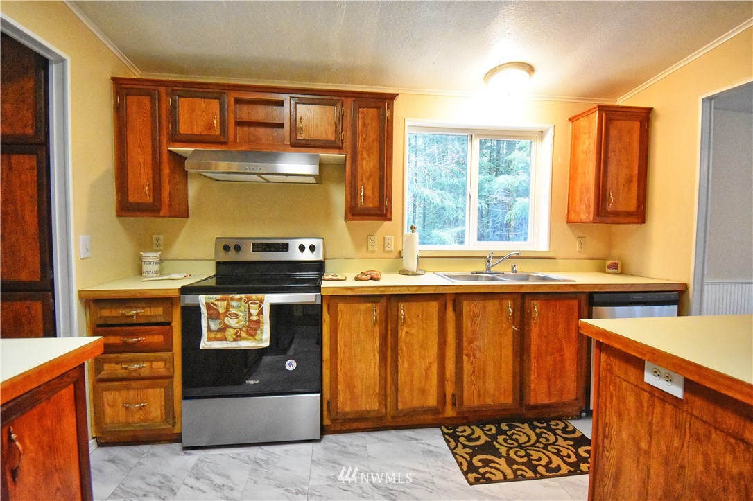 111 East Sleaford Road Shelton, WA 98584 - Photo 5 of 32 a kitchen with granite countertop a refrigerator and a stove