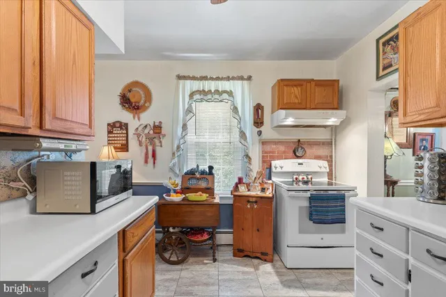 a room with stainless steel appliances kitchen island granite countertop a stove and a sink