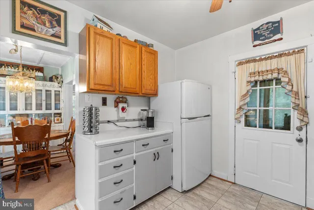 a kitchen with stainless steel appliances granite countertop a stove a refrigerator a dining table and chairs with wooden floor