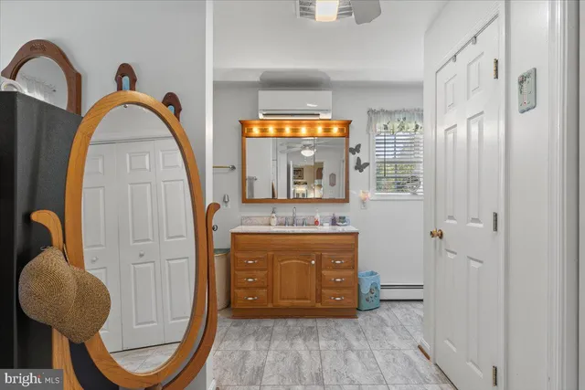 a bathroom with a granite countertop sink a mirror and shower