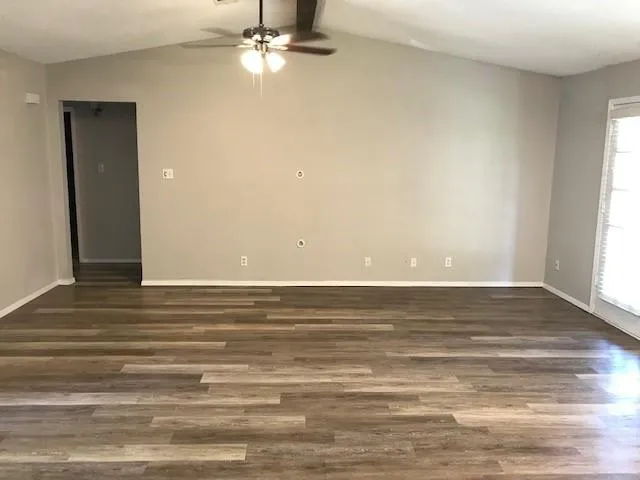 a view of a room with wooden floor and fan