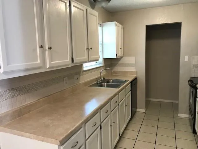 a kitchen with granite countertop a sink and a stove