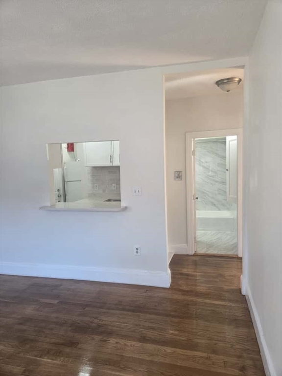 100 St Marys Street, Unit 1 Boston, MA 02215 - Photo 7 of 12 a view of an empty room with wooden floor and a window