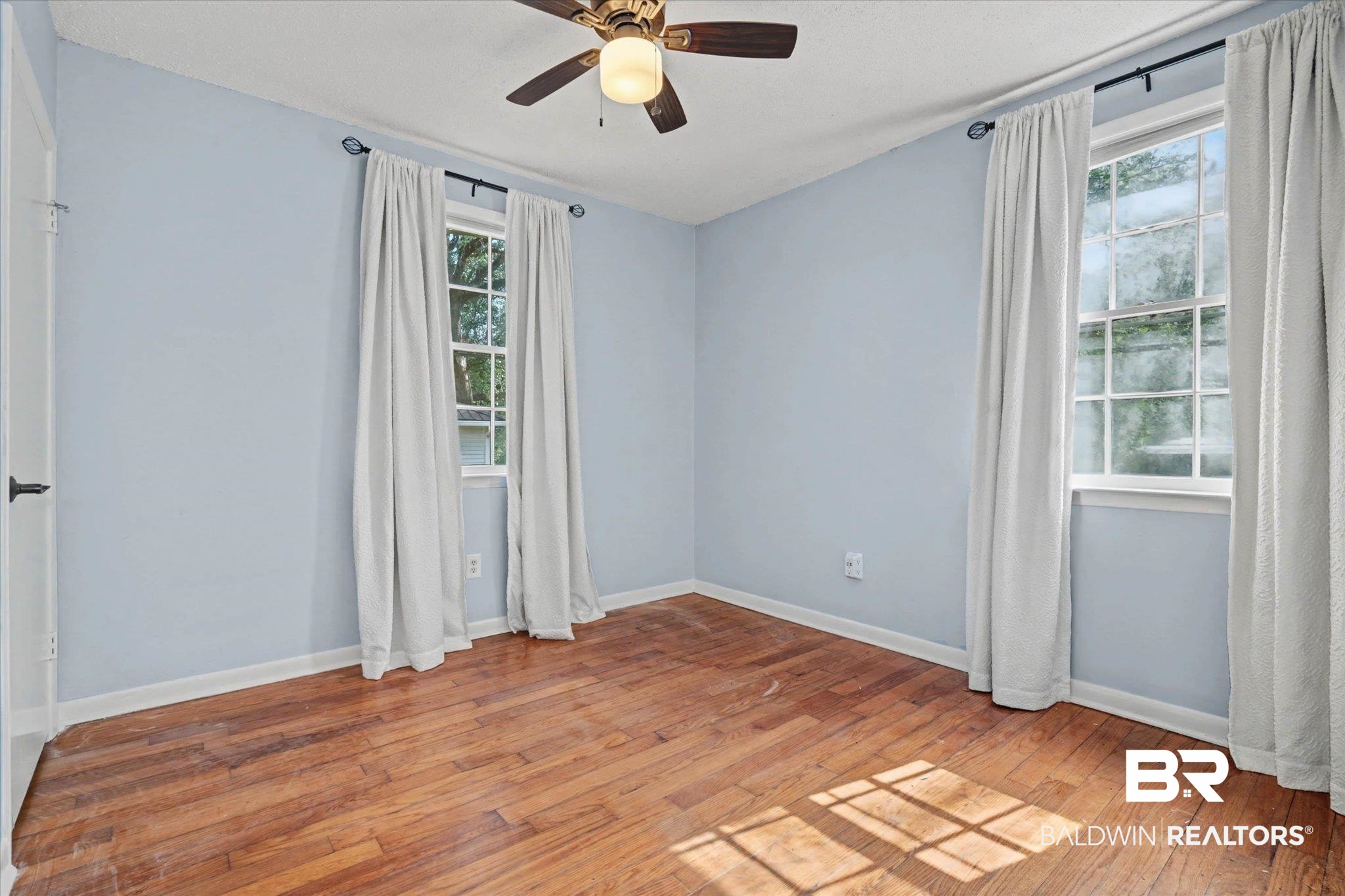 5117 Norton Lane Mobile, AL 36608 - Photo 18 of 35 Empty room featuring a ceiling fan, light wood finished floors, and healthy amount of natural light