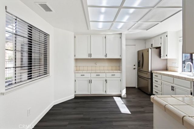 a kitchen with granite countertop white cabinets and stainless steel appliances