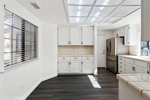 a kitchen with granite countertop white cabinets and stainless steel appliances