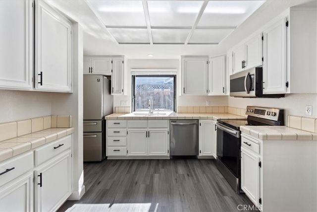 a kitchen with granite countertop white cabinets and white appliances