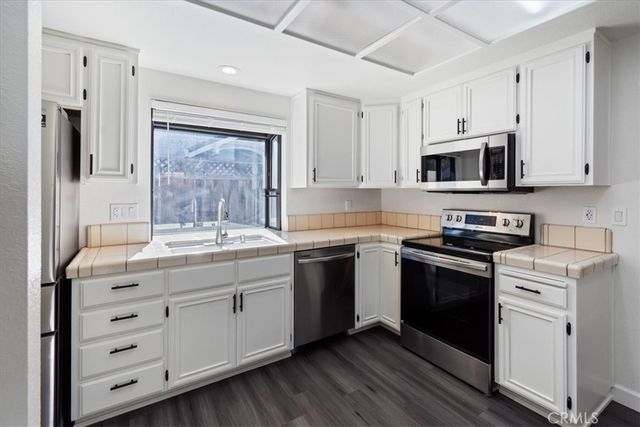 a kitchen with granite countertop white cabinets and stainless steel appliances