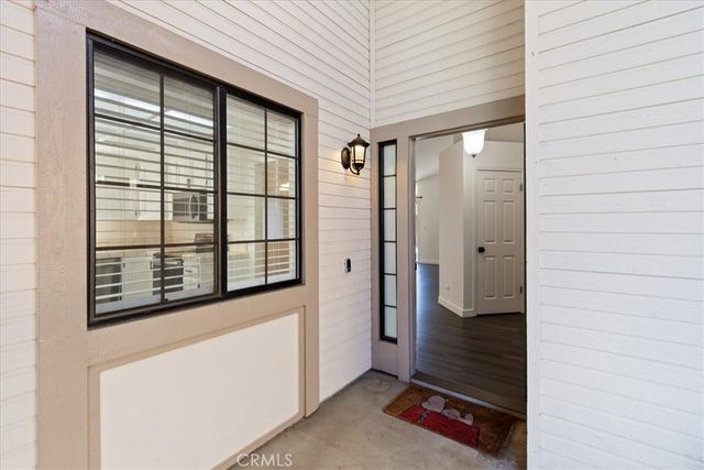 a view of a hallway with bathroom and wooden floor