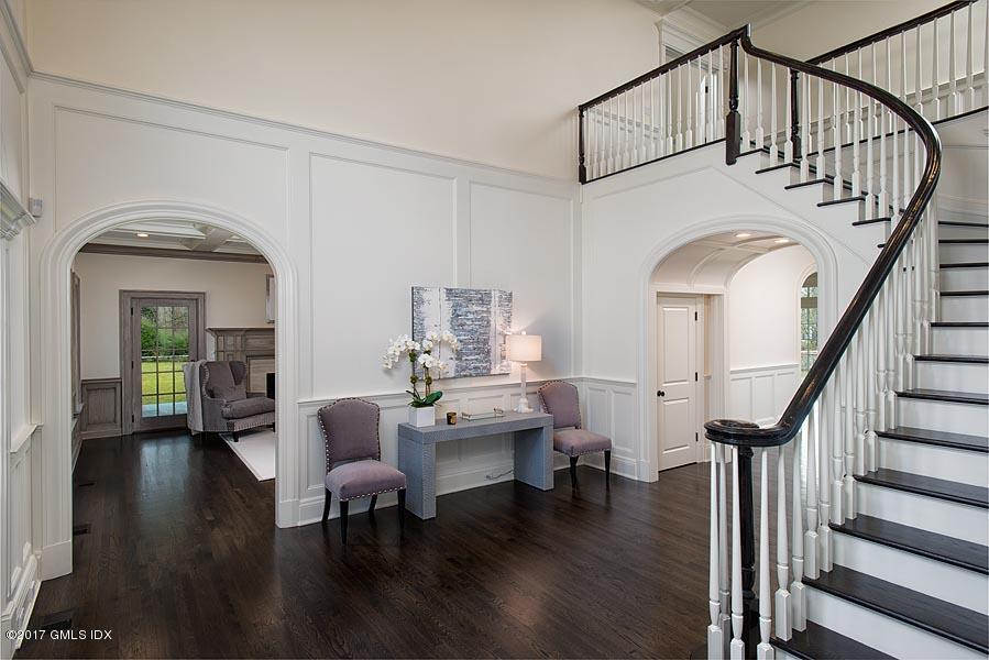 1 Doverton Drive Greenwich, CT 06831 - Photo 7 of 34 a living room with couches a dining table with wooden floor and a chandelier