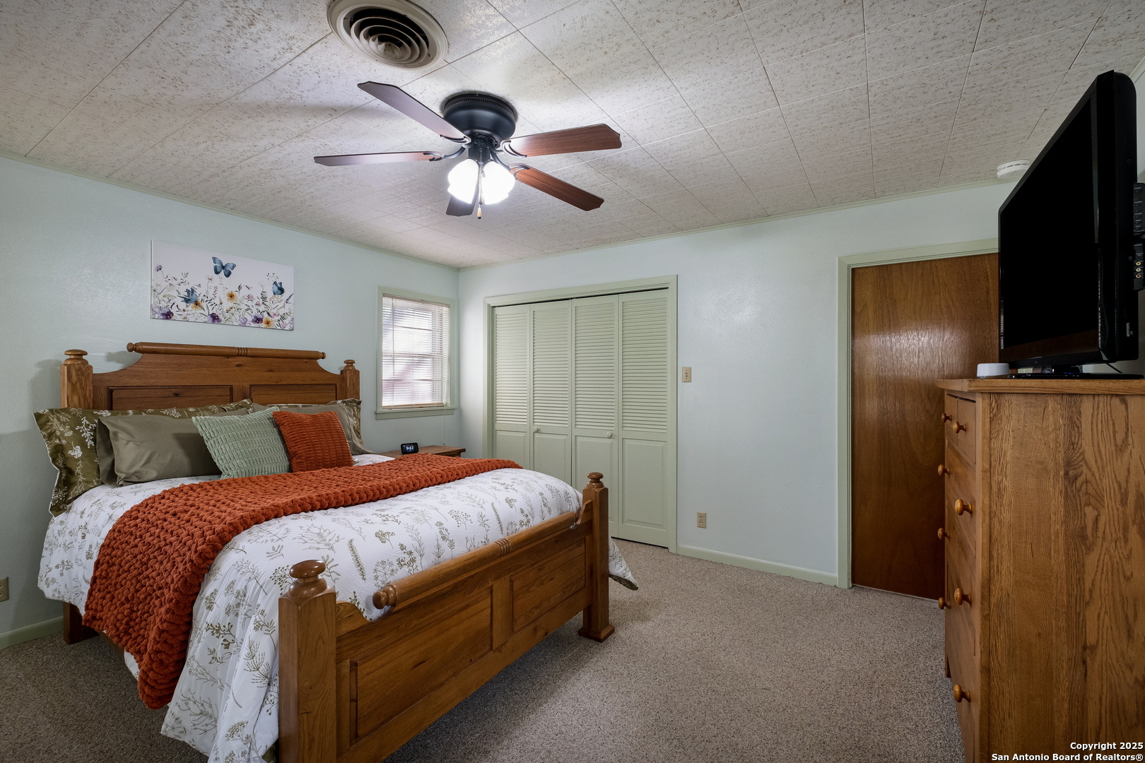 1109 27th Street Hondo, TX 78861 - Photo 9 of 21 a bedroom with a bed and a flat tv screen on the dresser