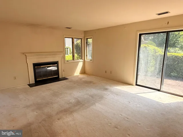 a view of an empty room with a fireplace and a window