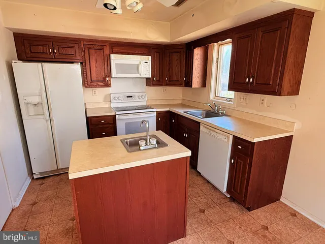 a kitchen with stainless steel appliances sink a refrigerator and cabinets