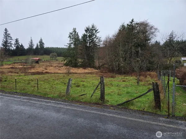 a view of a grassy field with trees in the background