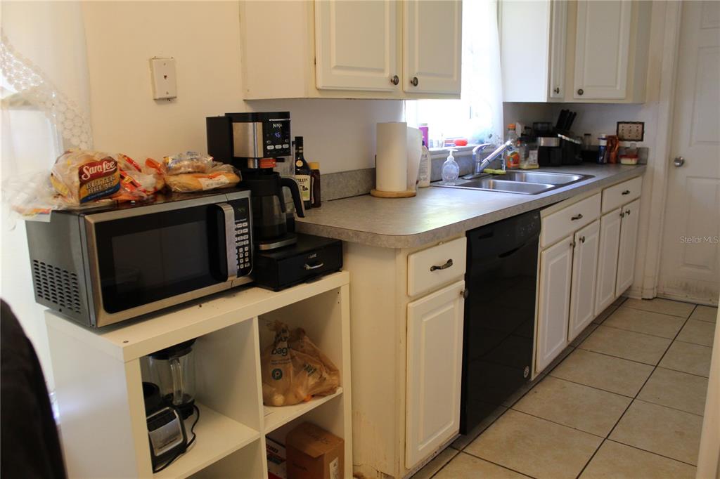 2755 Taylor Road Auburndale, FL 33823 - Photo 64 of 86 a kitchen with stainless steel appliances a stove a microwave a sink and cabinets