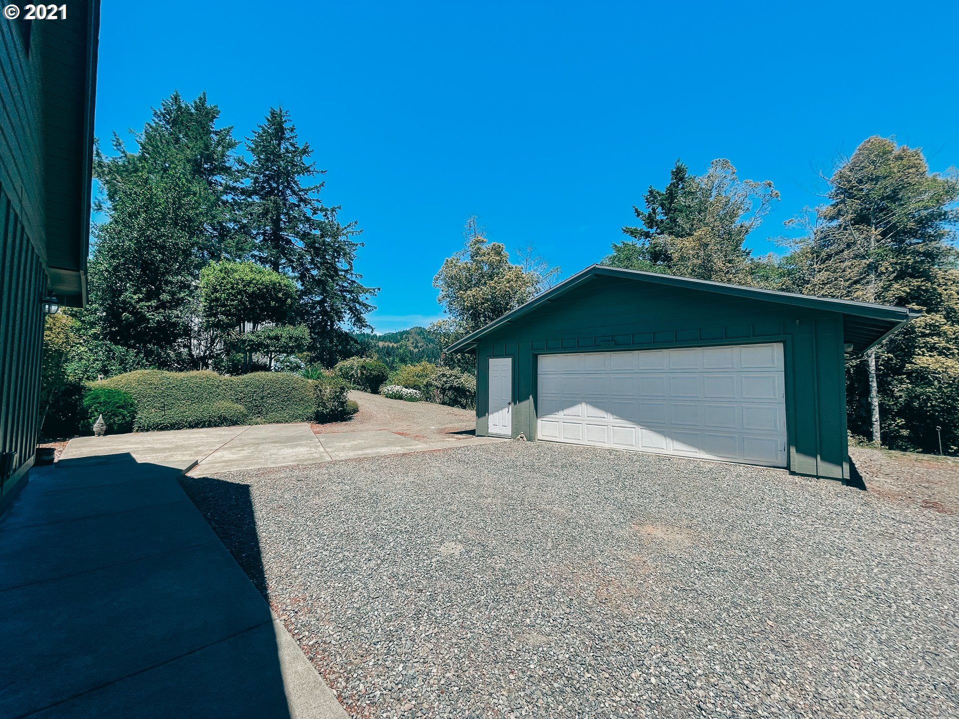 18148 Rainbow Rock Road Brookings, OR 97415 - Photo 31 of 32 a view of a house with a yard and garage
