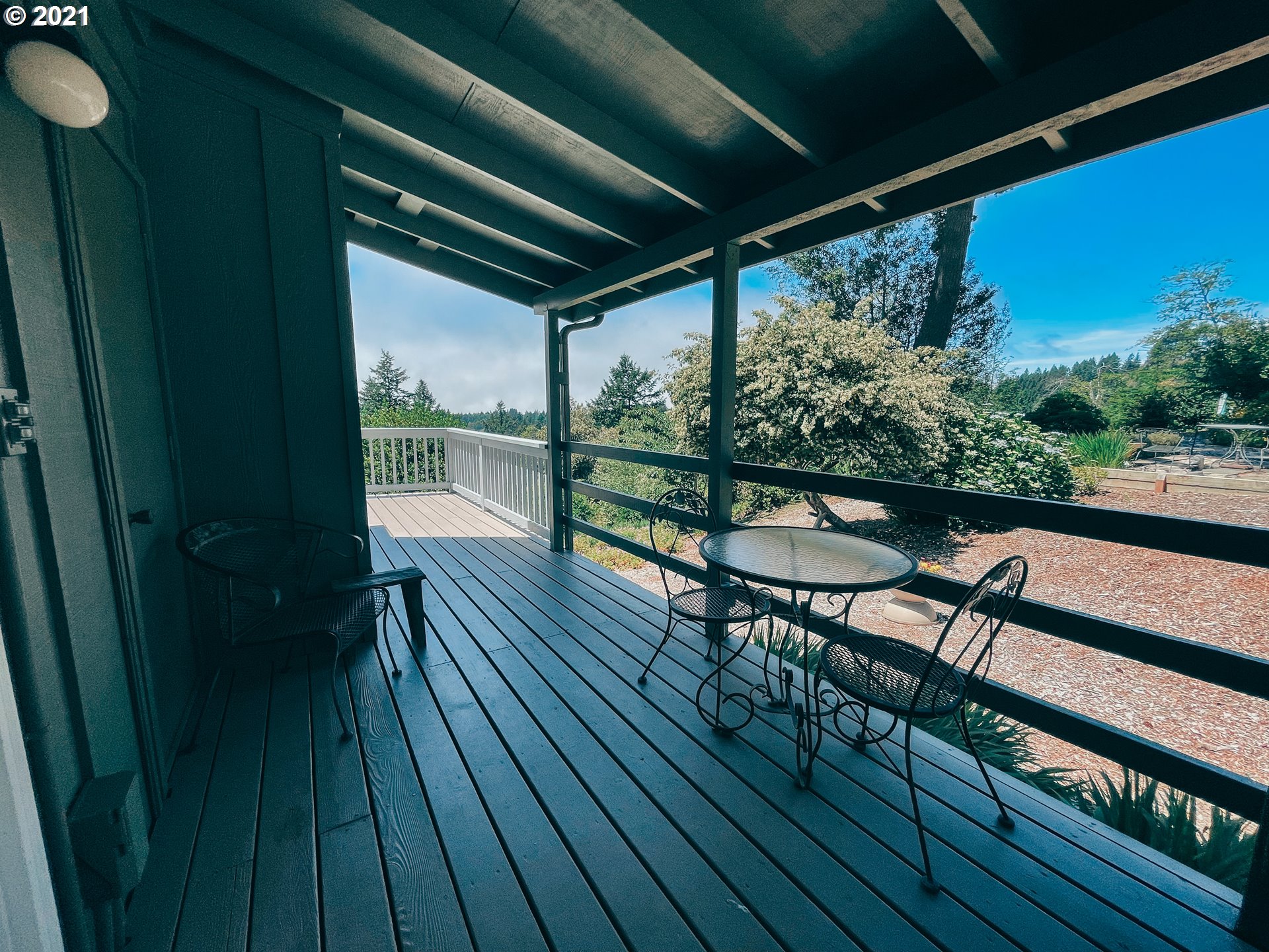 18148 Rainbow Rock Road Brookings, OR 97415 - Photo 8 of 32 a view of a chairs and table on the wooden deck