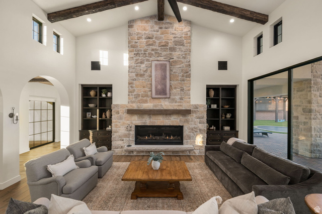 4871 South Homestead Way Washington, UT 84780 - Photo 14 of 151 Living area with arched walkways, wood-type flooring, a stone fireplace, and vaulted ceiling