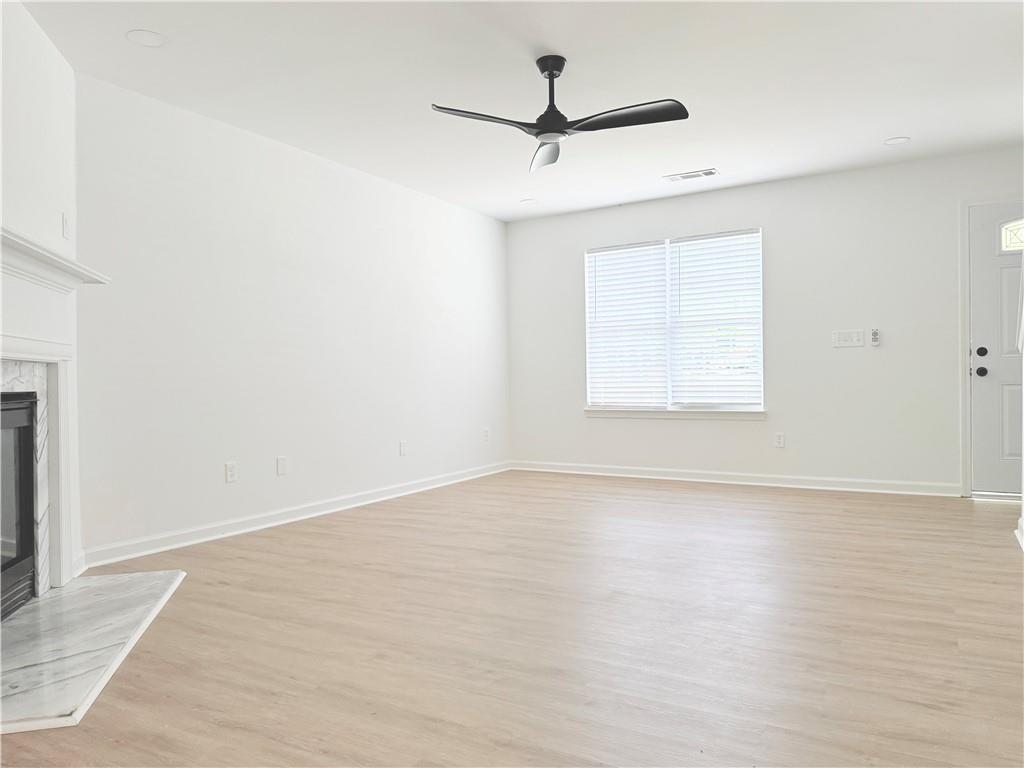 900 Melrose Park Place Lawrenceville, GA 30044 - Photo 4 of 26 an empty room with wooden floor ceiling fan and windows