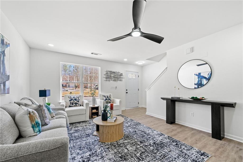 900 Melrose Park Place Lawrenceville, GA 30044 - Photo 5 of 26 a living room with furniture a window and a chandelier