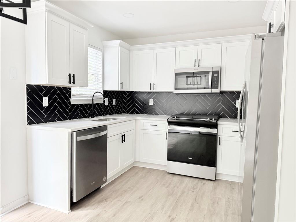 900 Melrose Park Place Lawrenceville, GA 30044 - Photo 8 of 26 a kitchen with stainless steel appliances granite countertop a stove and a microwave