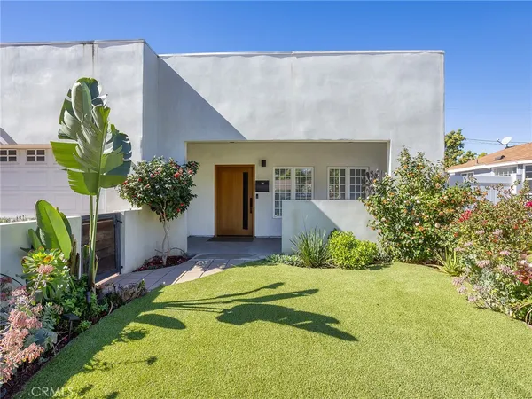 a front view of a house with a garden and plants
