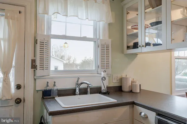 a living room with furniture and a flat screen tv with kitchen view