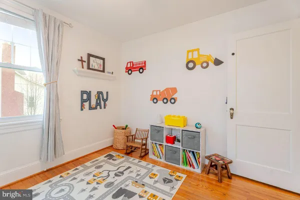 a front view of a house with a garden and trees