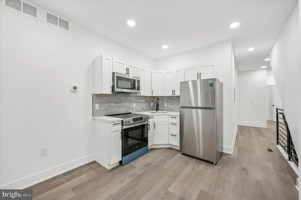 a kitchen with stainless steel appliances granite countertop a refrigerator stove a sink and a microwave