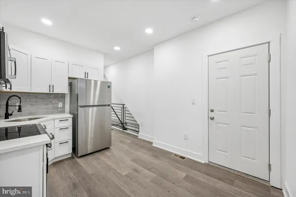 a kitchen with stainless steel appliances a refrigerator and a stove top oven