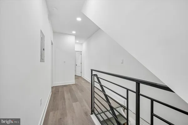 a view of a hallway with wooden floor and staircase