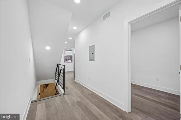 a view of a hallway with wooden floor and a workspace