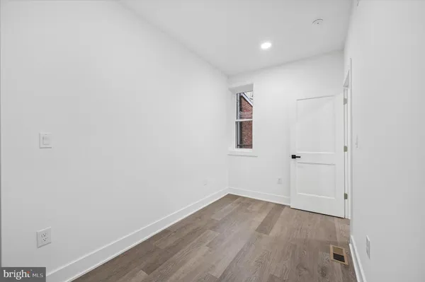 a view of a room with wooden floor and white walls