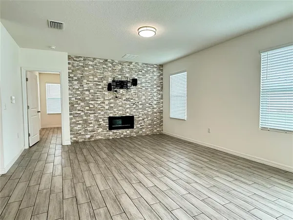 a view of empty room with wooden floor and fireplace