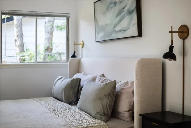a bed sitting in a bedroom next to a window