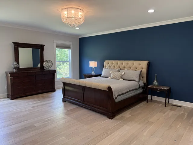 an empty room with wooden floor and a ceiling fan