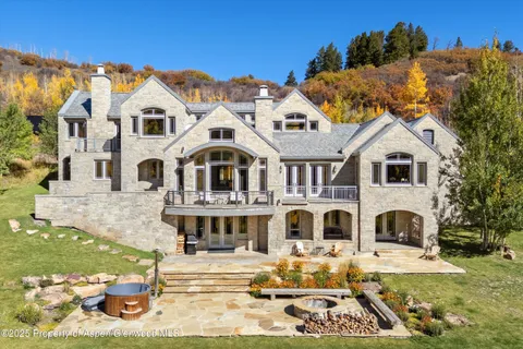 a view of a white building among the yard and large trees