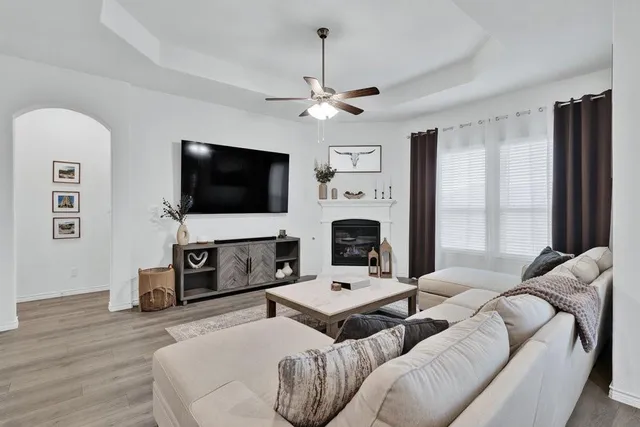 a living room with furniture a flat screen tv and a fireplace