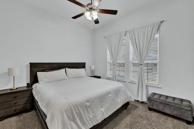 a large bed sitting in a bedroom next to a window