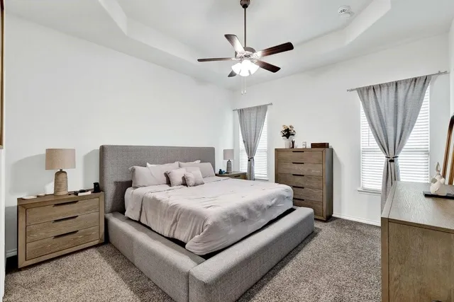a bedroom with a bed and dresser with wooden floor