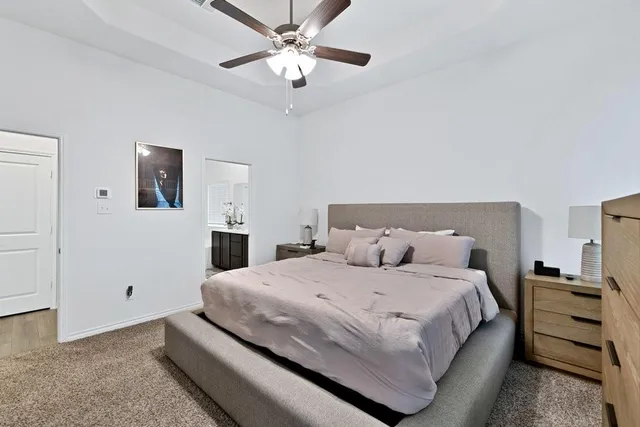 a bedroom with a large bed and a chandelier