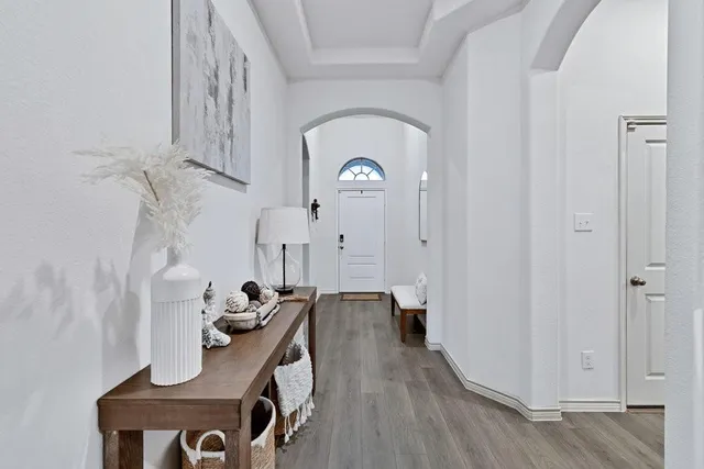 a view of a hallway with entryway wooden floor and front door